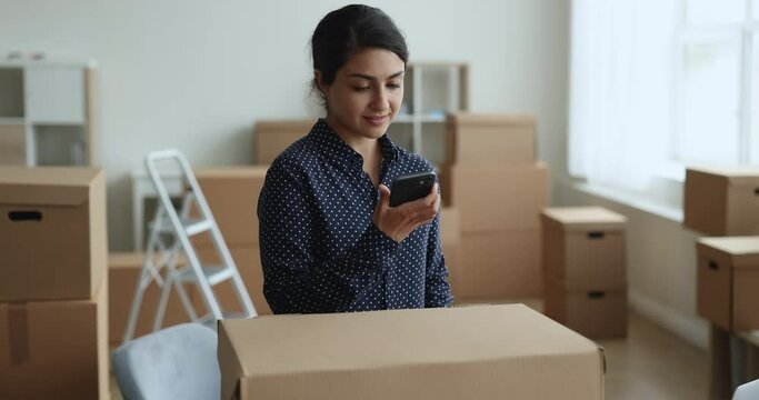 Young Indian businesswoman calls to courier service for sending prepared parcel box for customer. Client of reliable, trustworthy, express transporting company, quick dispatch, distribution, business