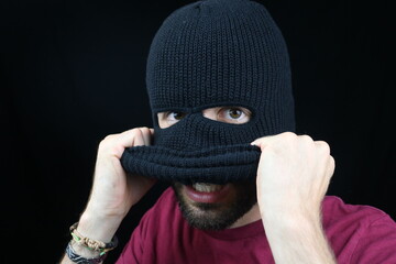 Young Man is removing Balaclava