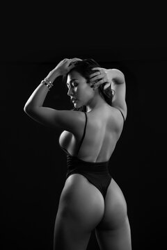 

Rear view of sexy woman with fit body on black background. Asien woman standing with her back to camera. black and white
