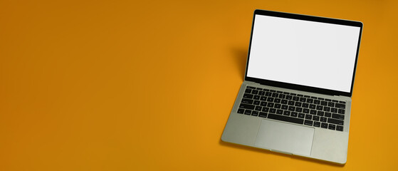 Fototapeta na wymiar Laptop with white empty screen on yellow background with copy space for your advertise text
