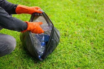 Man picking up plastic waste to clean up at a park