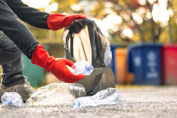 Man picking up plastic bottle, garbage collecting in a forest cleaning planet, help garbage collection charity 