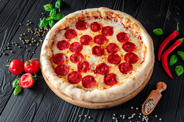 Tasty pepperoni pizza and cooking ingredients tomatoes basil