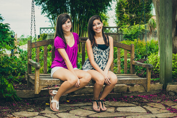Teenage girls relaxing bench garden