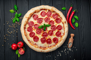 Tasty pepperoni pizza and cooking ingredients tomatoes basil
