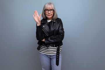 informal gray-haired middle-aged woman grandmother in a rocker jacket on a bright background with...