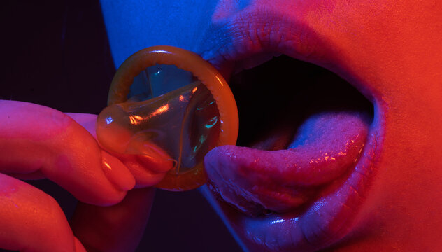 Mouth of a girl with tongue licking a condom. Sexy woman mouth with condoms. Sexy woman with condom in lips, closeup. Erotic concept. Condom in open mouth and sexy lips. Safe sex. Girl using condom.