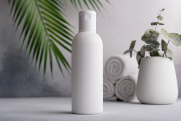 White blank packaging cosmetic plastic bottle with palm leaves - obrazy, fototapety, plakaty