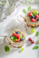 Sweet granola with oat flakes and yoghurt in jar.
