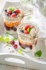 Fresh and healthy granola in jar with yoghurt.
