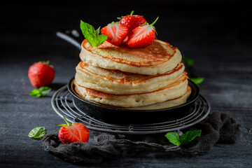Yummy and fresh american pancakes with powdered sugar and fruits.