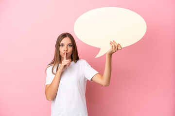 Young Lithuanian woman isolated on pink background holding an empty speech bubble and doing silence...