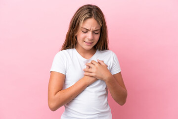 Little caucasian girl isolated on pink background having a pain in the heart