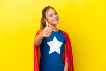 Super Hero little girl isolated on yellow background with thumbs up because something good has happened © luismolinero