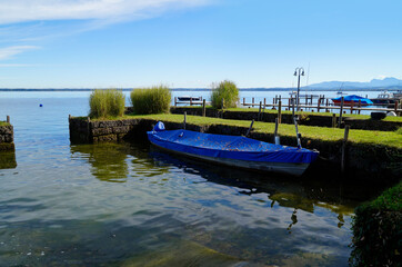 a scenic view with an old fishing boat on island Frauenchiemsee or Fraueninsel on lake Chiemsee on a sunny October day in Bavaria (Germany)	
