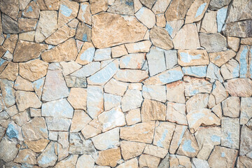 Masonry wall of natural brown stones with irregular pattern texture background. Typical masonry wall in Spain