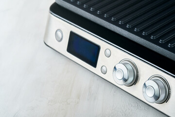 Fototapeta premium Electric grill. Modern kitchen portable grill tool for modern kitchen for grilling meat, vegetables and snacks for dinner or party on light gray background. Place for text or advertisement. Mock up.