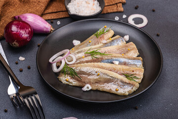 Fillet of pickled marinated sea herring fish with shallots and dill. Cutlery, vintage napkin
