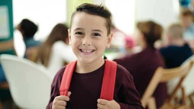 Adorable hispanic boy student smiling confident standing at classroom