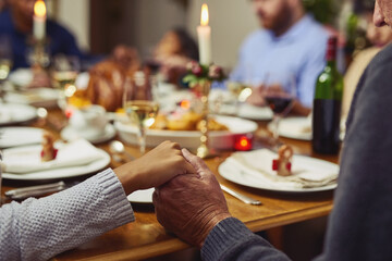 Fototapeta na wymiar Prayer, thanksgiving and hand holding with family at table in dining room for holiday, food or worship. Praying, support and gratitude with closeup of people at home for kindness, dinner and love