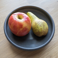 Apple and pear on a ceramic plate