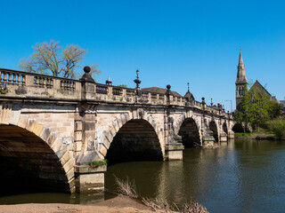 The stone arches of the 18th century Grade II listed English Bridge which crosses the River Severn in Shrewsbury, UK. Clear blue sky. Space for text.
