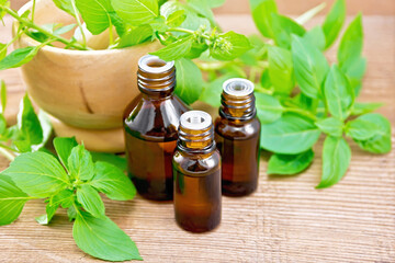 Oil with basil and mortar on wooden board