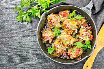 Rolls of eggplant with meat in pan on black board top