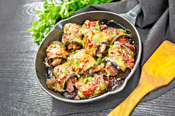 Rolls of eggplant with meat in pan on table