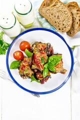 Rolls of eggplant with meat in plate on light board top