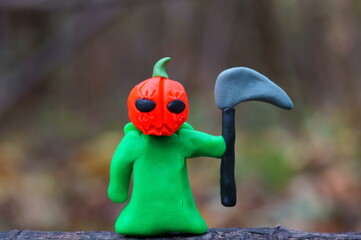 A ghost figurine with a red pumpkin and a scythe.