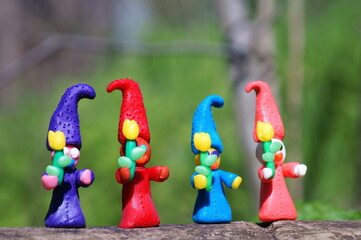 Figures of funny smiling gnomes with flowers.