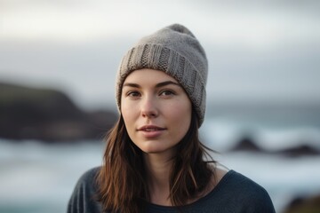 Portrait of a beautiful young woman in winter hat at the beach