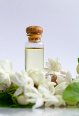Obraz na płótnie Canvas White mogra or arabian jasmine or Jasminum sambac flower Buds Essential oil in glass bottle beauty treatment.