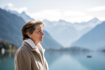 Portrait of senior woman standing by lake in Alps, Austria.