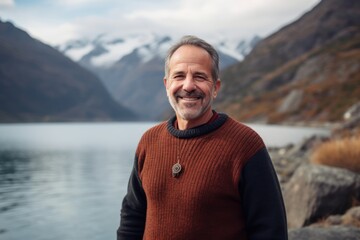 Portrait of a smiling senior man standing by a lake in New Zealand