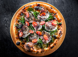 Pizza Italiana served with ham, cheese, tomatoes and rucola