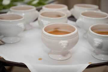 Split pea soup in miniature tourine bowls are served to guests in restaurant