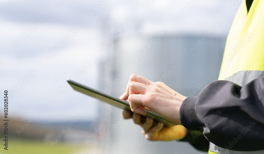 Aufkleber engineer with digital tablet on a background of gas tanks.