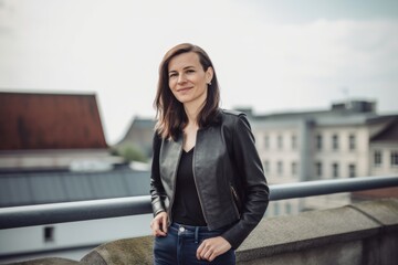Fototapeta premium Portrait of a young woman in a leather jacket on the roof