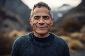 Portrait of a smiling middle-aged man on a background of mountains