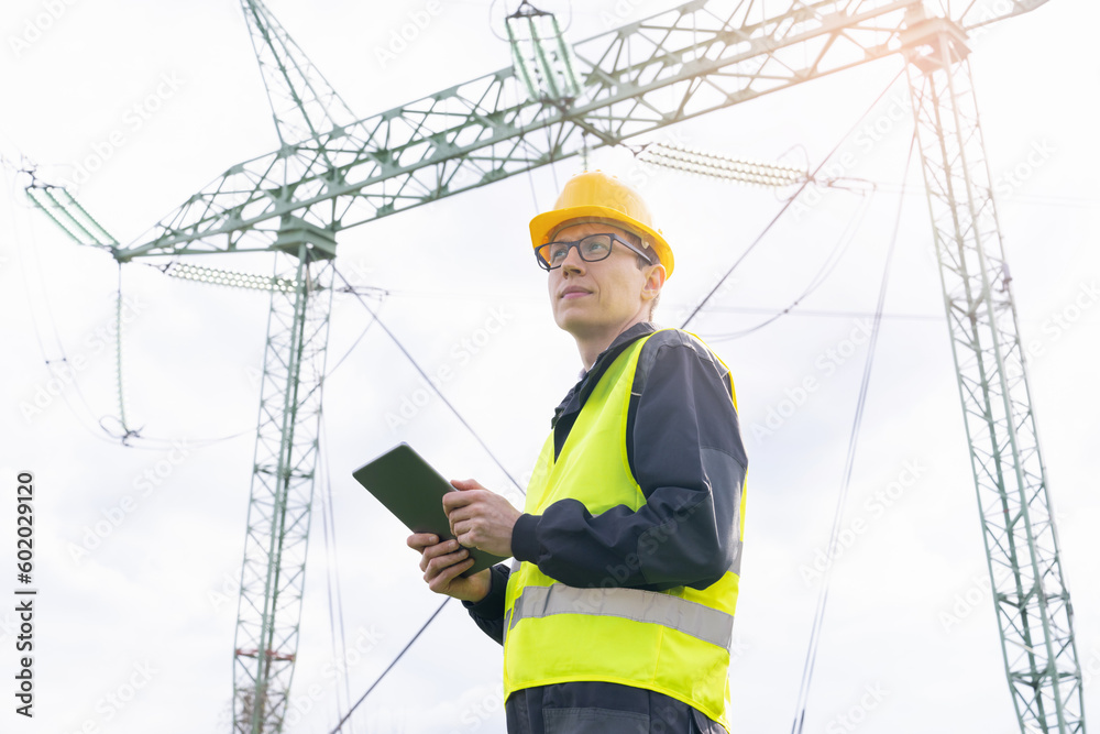 Aufkleber Engineer with digital tablet on a background of power line tower.
