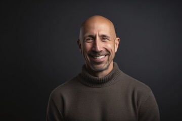Fototapeta premium Portrait of a bald man in a sweater on a dark background