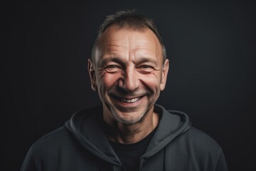 Obraz premium Close up portrait of a smiling middle-aged man on black background