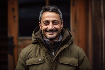 Fototapeta na wymiar Lifestyle portrait photography of a grinning man in his 40s wearing a warm parka against a rustic wooden background. Generative AI