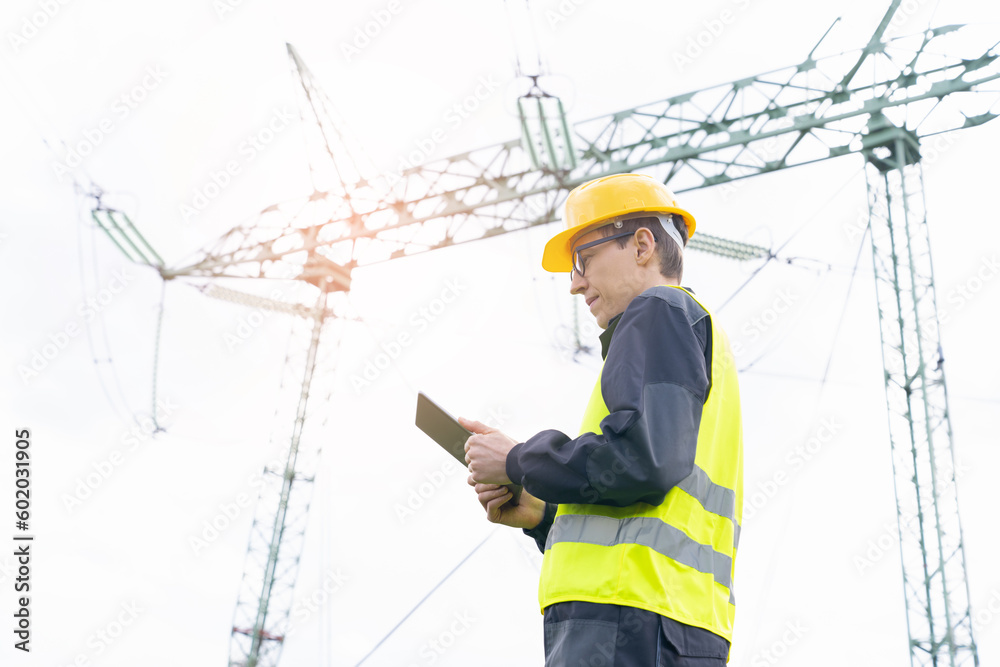 Aufkleber Engineer with digital tablet on a background of power line tower.