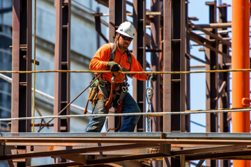 Construction worker climber on a site wearing construction safety equipment working at height, Generative AI