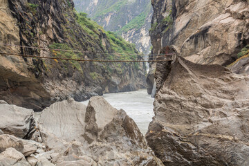 Hanging foot bridge over Jinsha river in Tiger Leaping Gorge, Yunnan province, China