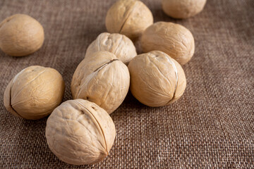 Mixed nuts on a white wooden fabric texture background.
