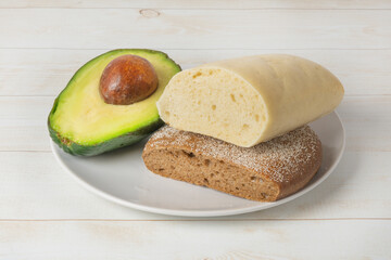 Ripe green avocado with different breads on a plate. An avocado sandwich can be made with white and brown bread